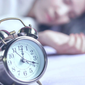 woman-sleeping-in-bed-with-alarm-clock-in-foreground_34670-169